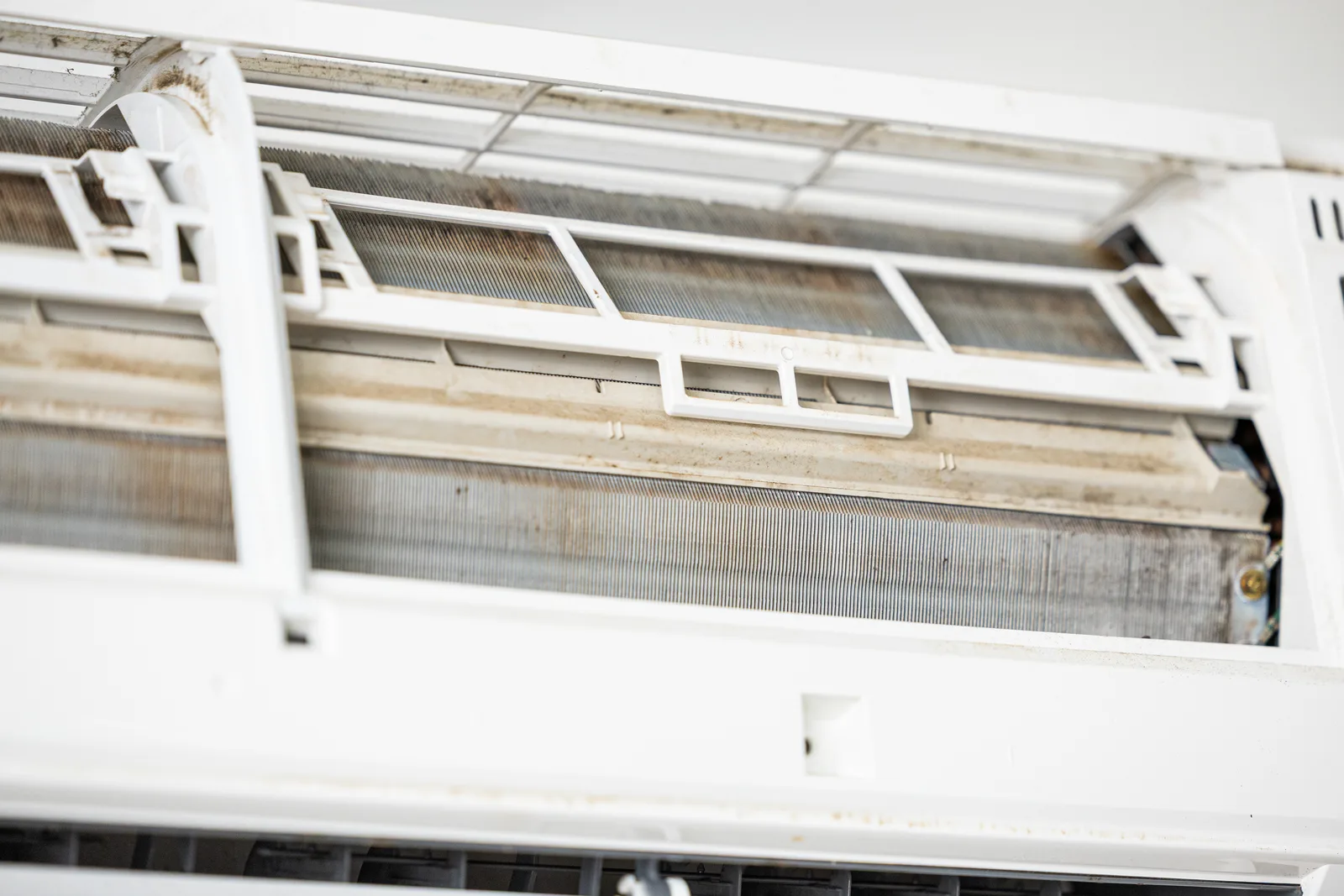 Technician inspecting air conditioner coils for faults