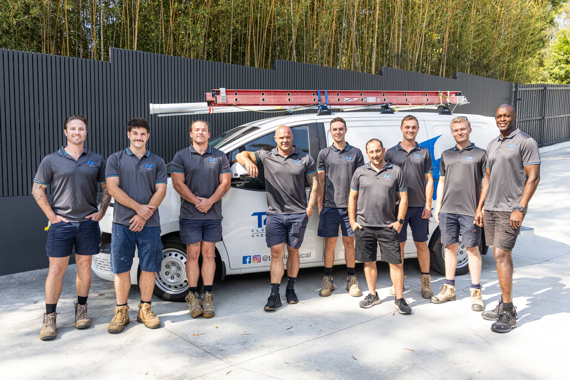 The full team lined up with a service van